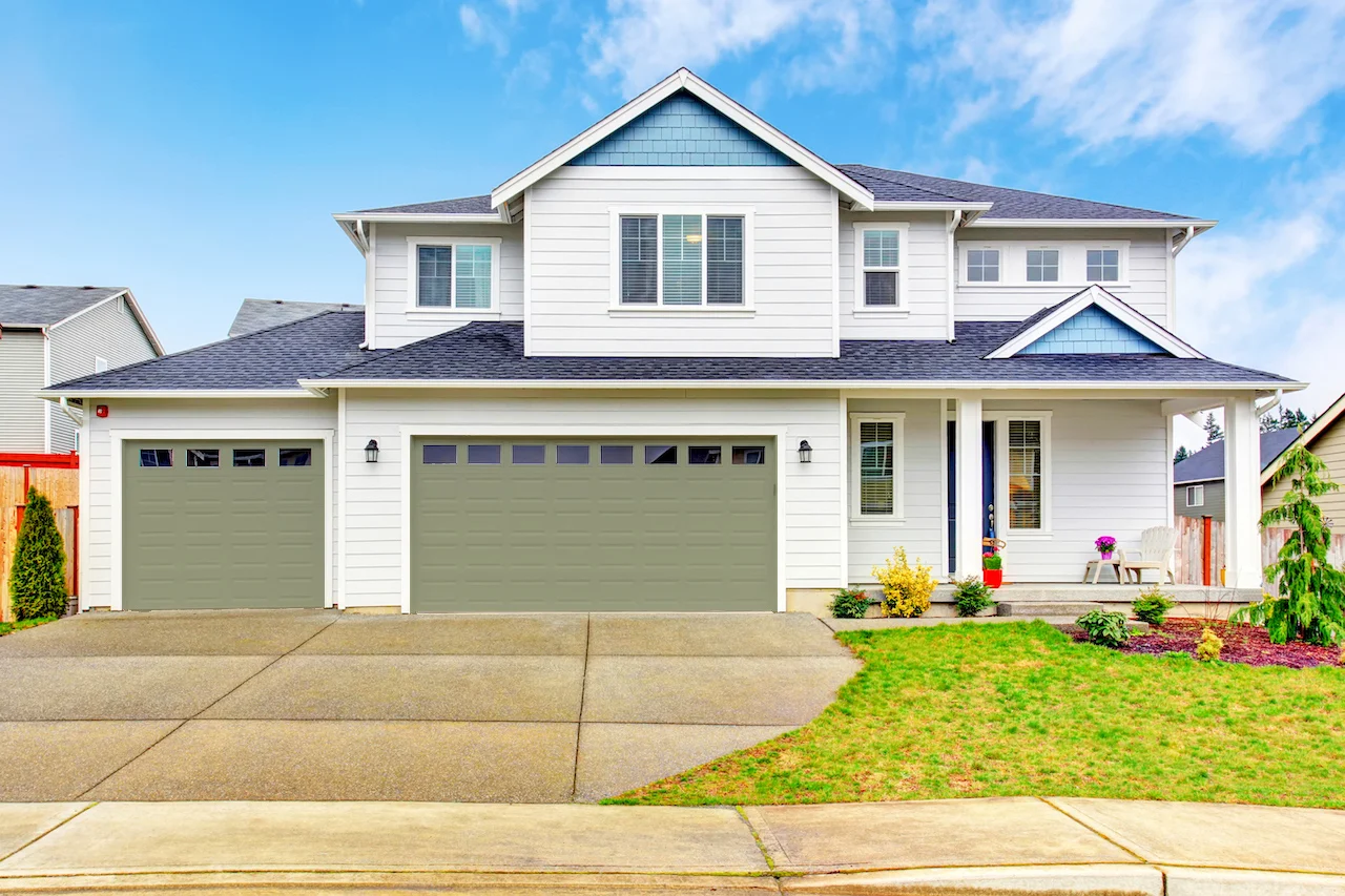 white house with sage green garage door