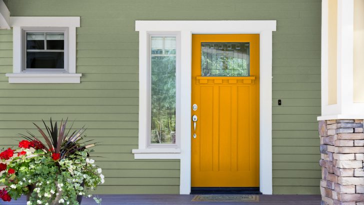 warm orange front door and sage green house