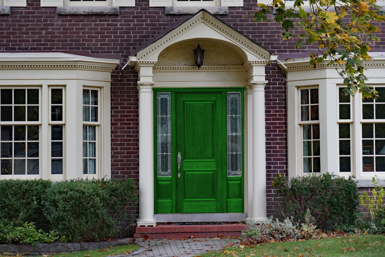 brown brick house with forest green front door