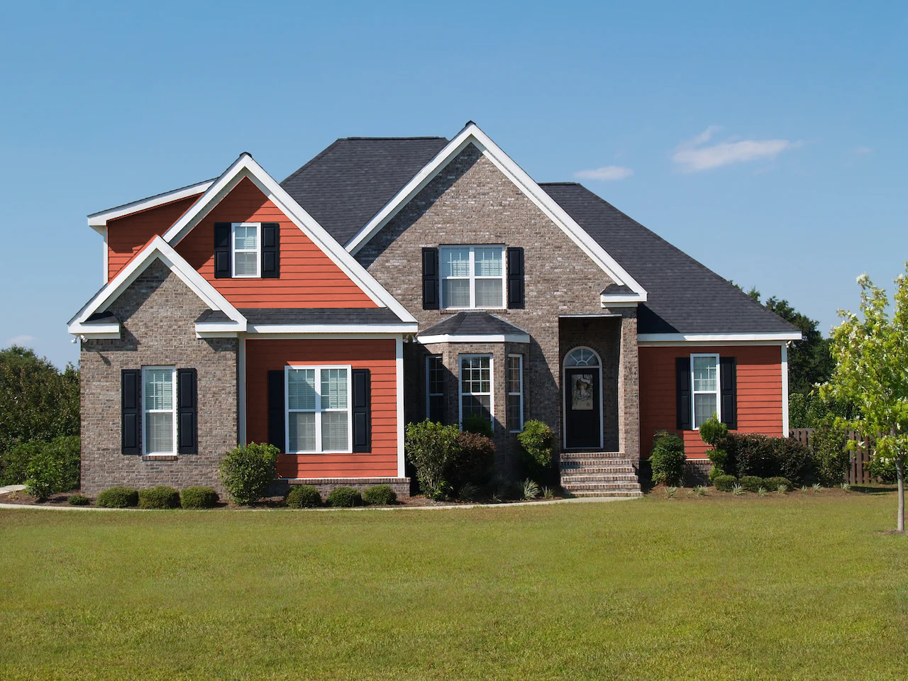 brown brick house with terracotta siding